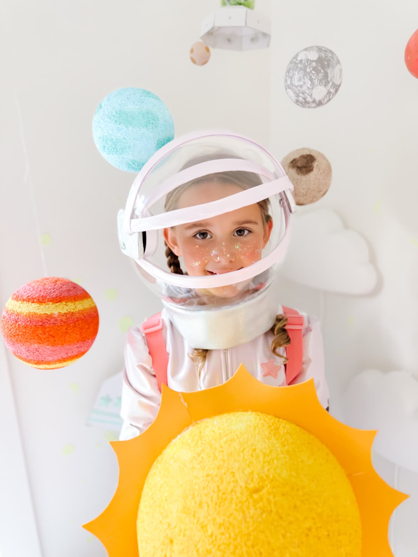 Child in the clear helmet with a felt sun decoration on the visor