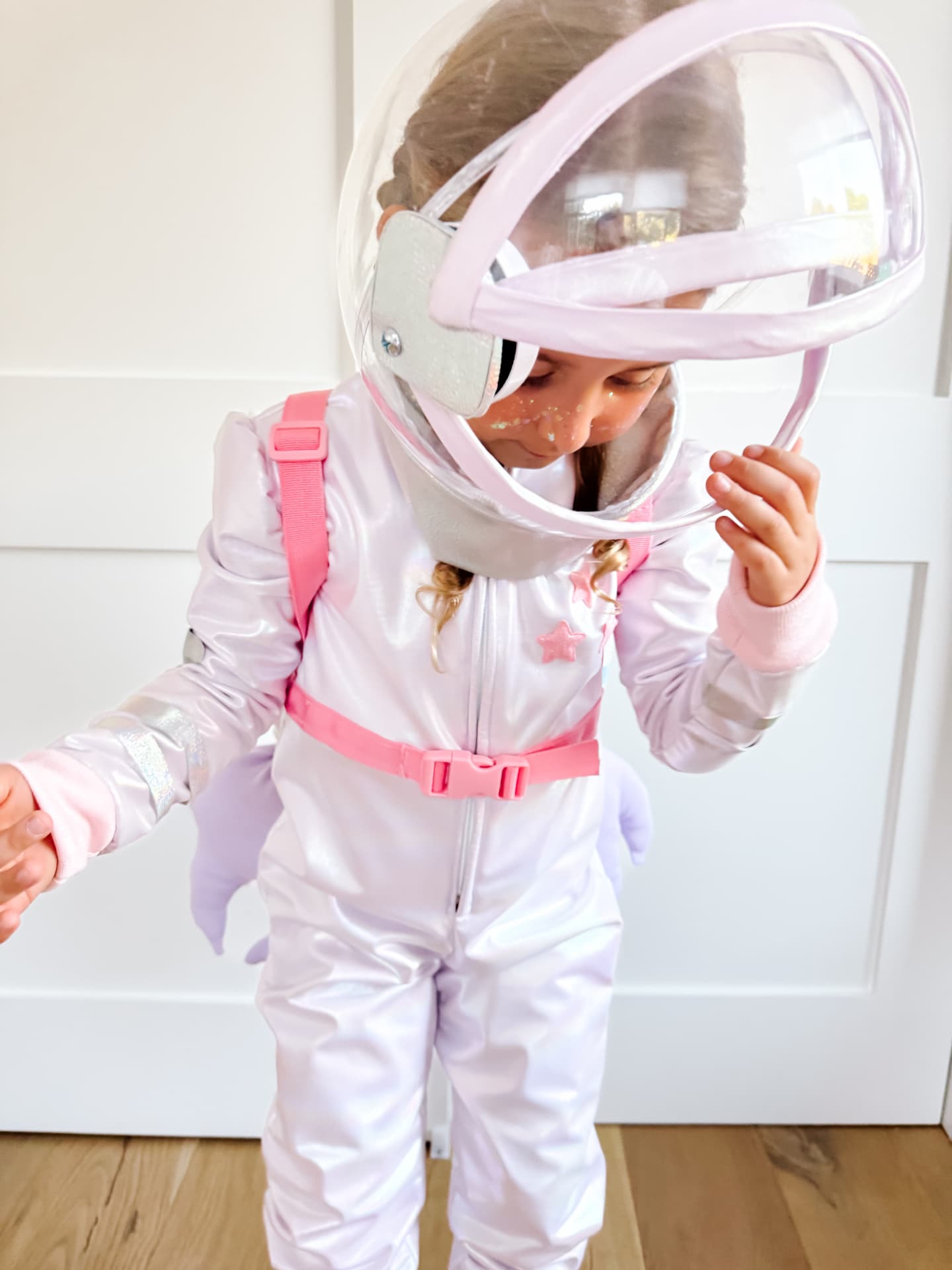 Child peeking into the astronaut helmet visor